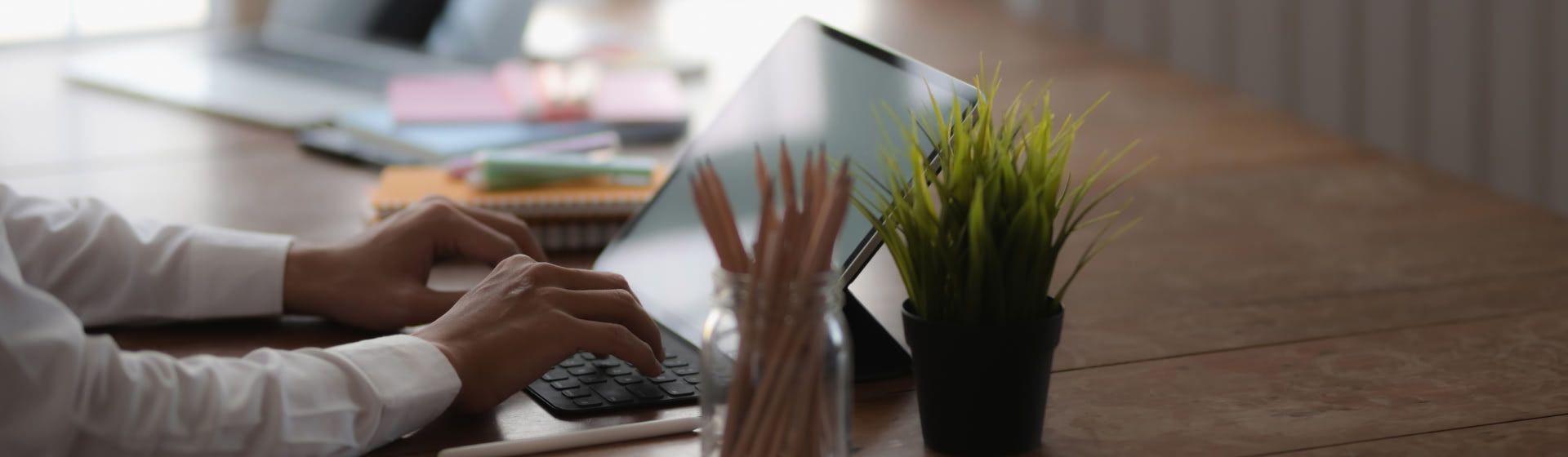 Manos de una persona trabajando delante de un portátil/tablet