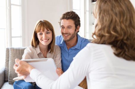 Pareja soriendo encuentra piso en una inmobiliaria