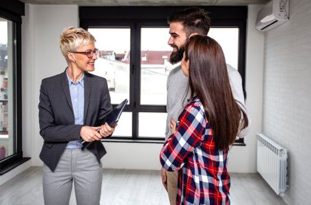 Pareja visitando un piso con una agente inmobiliaria