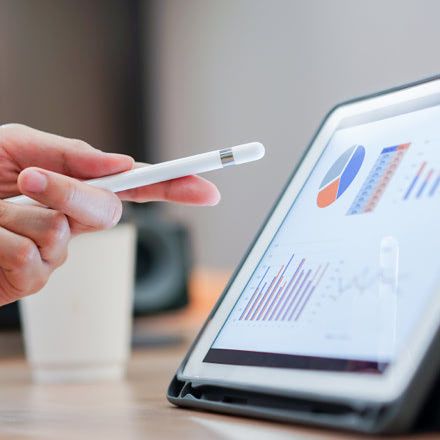 Mano apuntando a una tablet que muestra estadísticas