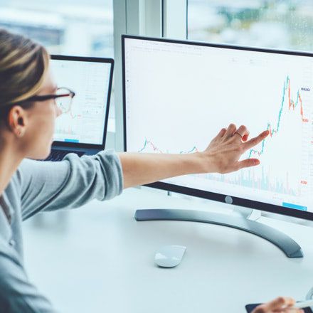 Mujer señalando a unos gráficos en una pantalla